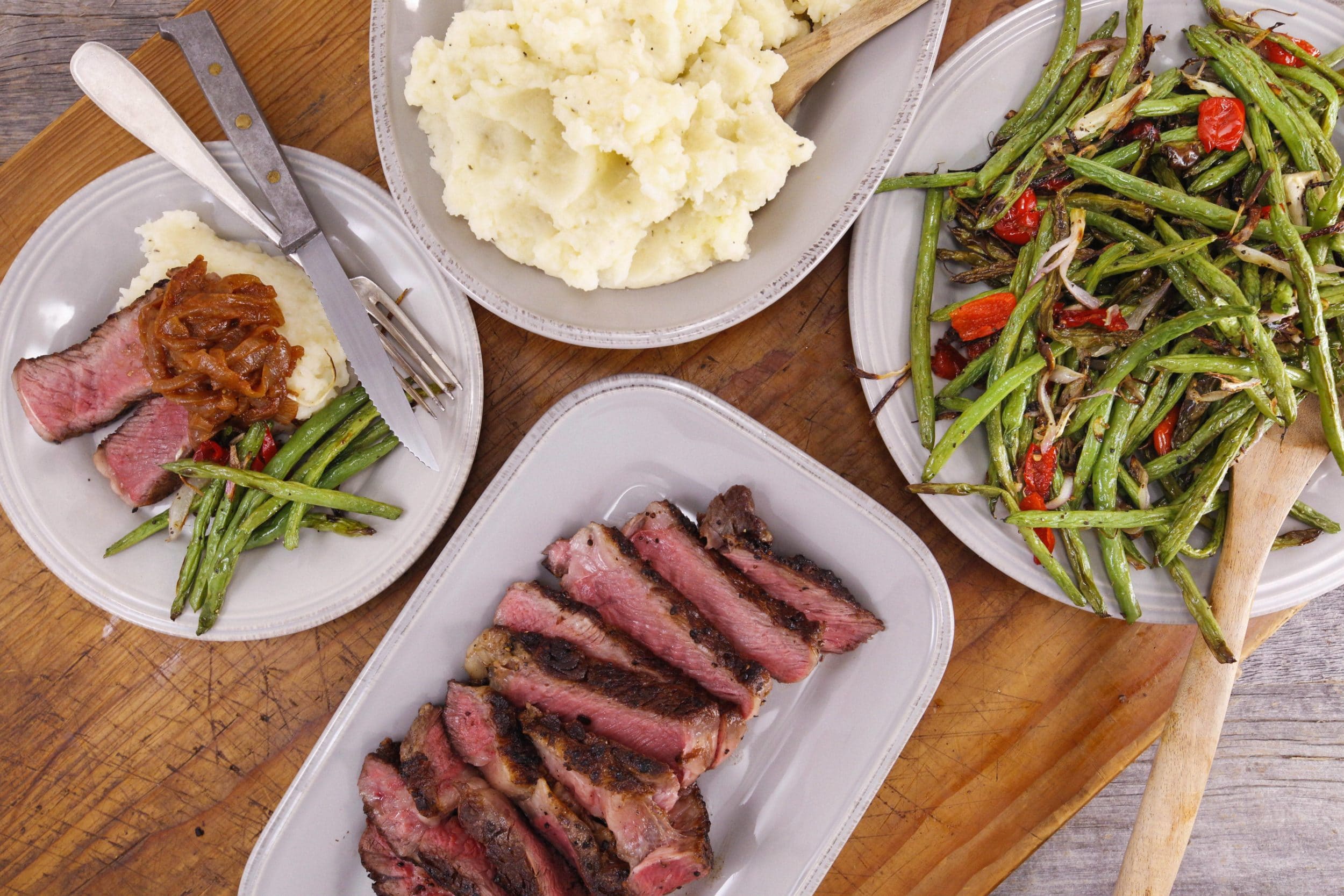 Sliced Steak with Pimenton Barbecue Onions, Roasted Green Beans and Manchego Potatoes