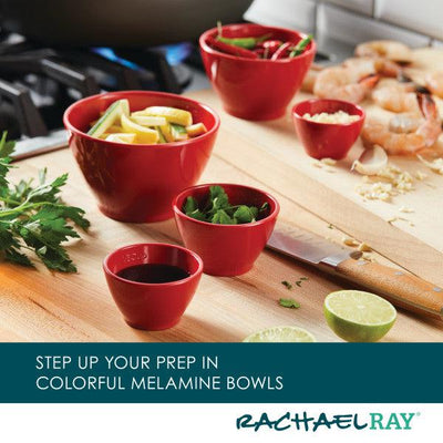 Red melamine bowls with ingredients on a kitchen counter near a cutting board.