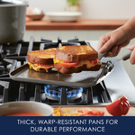 Grilled cheese sandwiches cooking on a stovetop griddle.