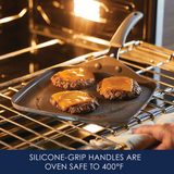 Cheeseburgers on a skillet in an oven, silicone grip handle visible.