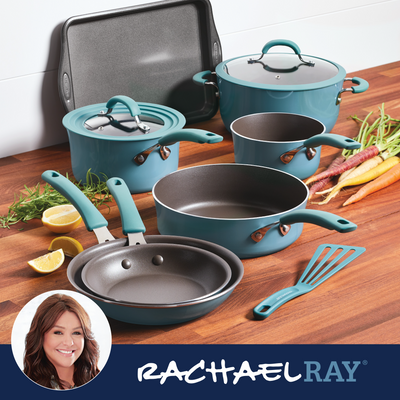 Cookware set with blue handles and diverse vegetables on a wooden surface.