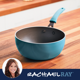 A teal saucepan on a wooden countertop with a brand logo at the bottom.