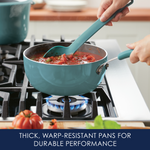 Person stirring sauce in a blue pot on a gas stove.