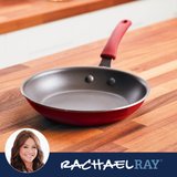 Red skillet on wooden countertop with Rachael Ray branding in the corner.