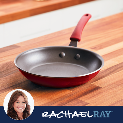 Red skillet on wooden countertop with Rachael Ray branding in the corner.