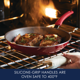 Pan with steaks inside an oven, showing silicone-grip handle.