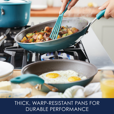 Two pans on a stove: one with potatoes, another with sunny-side-up eggs.