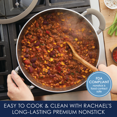 A pot of chili with beans and corn on a stovetop, wooden spoon inside.