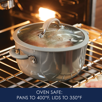 Gray pot with a lid in the oven, labeled oven safe for specific temperatures.