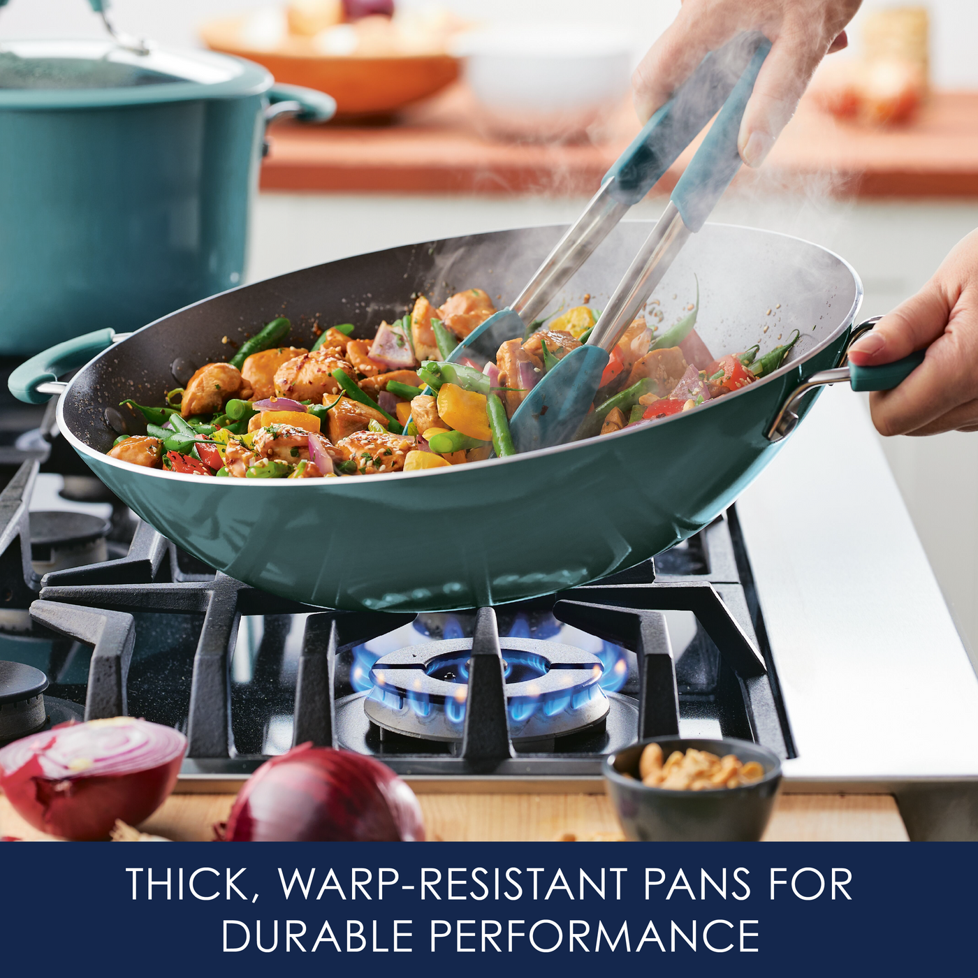 Person cooking stir fry in a green pan on a gas stove.