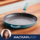 Frying pan with blue handle on a wooden surface, Rachael Ray branding.