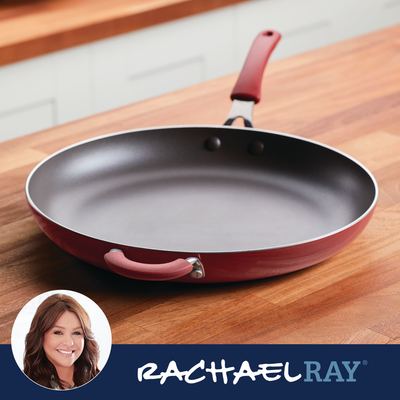 Red nonstick frying pan on wooden counter, with a small Rachael Ray logo.