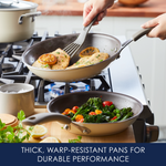 Two pans on a stove cooking chicken with lemon and vegetables.