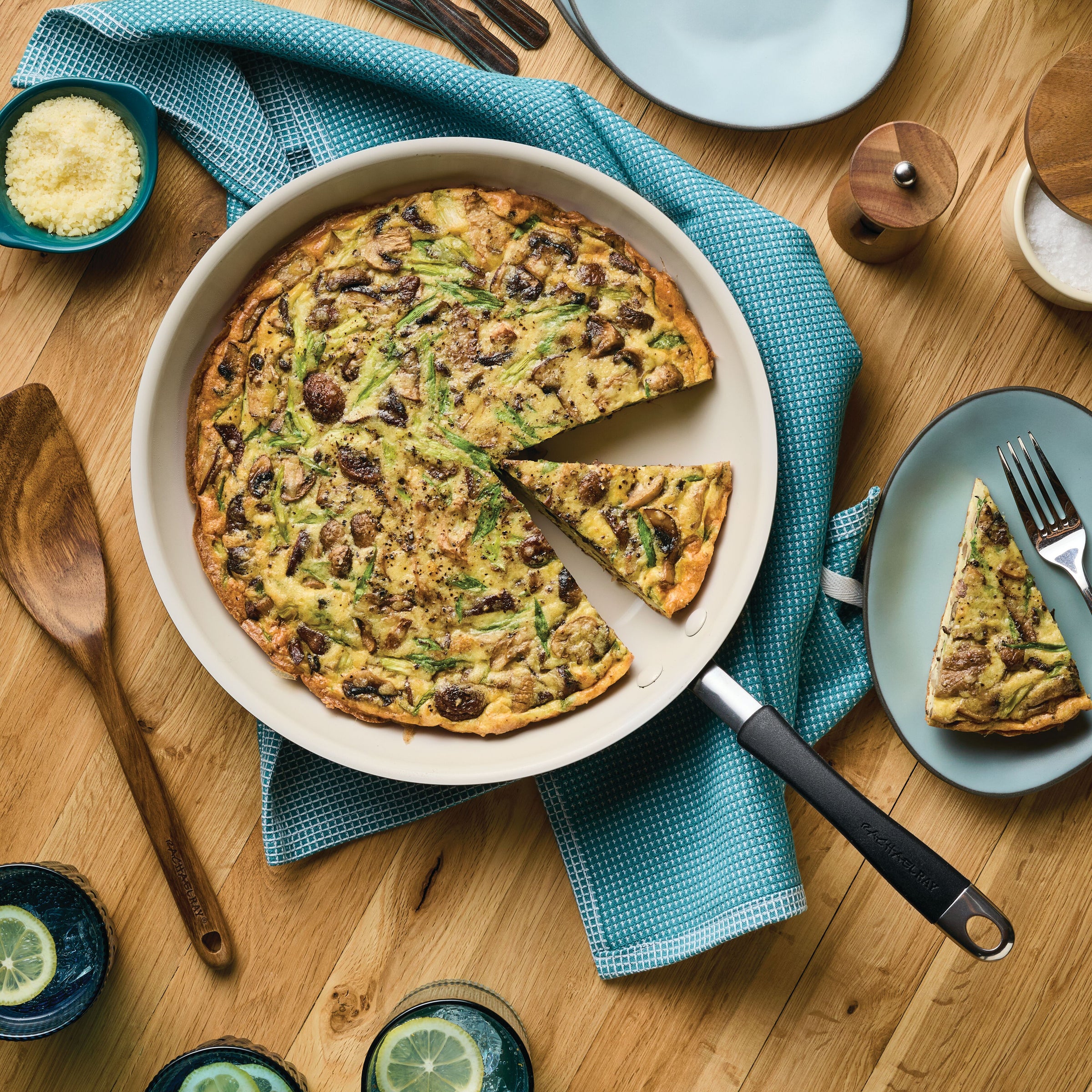 A vegetable frittata in a pan with a slice on a plate beside it.
