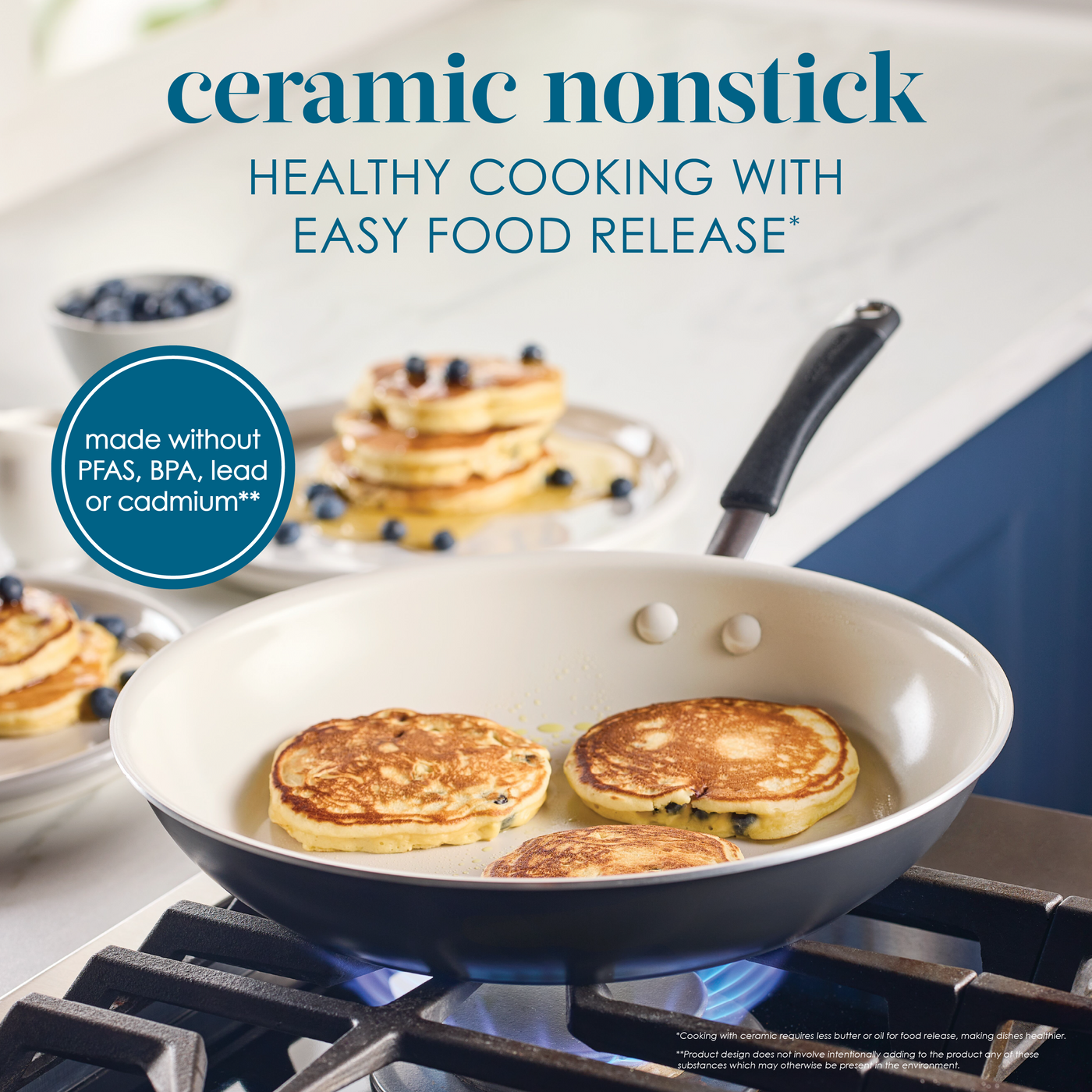 Ceramic nonstick pan with pancakes cooking on a stove.