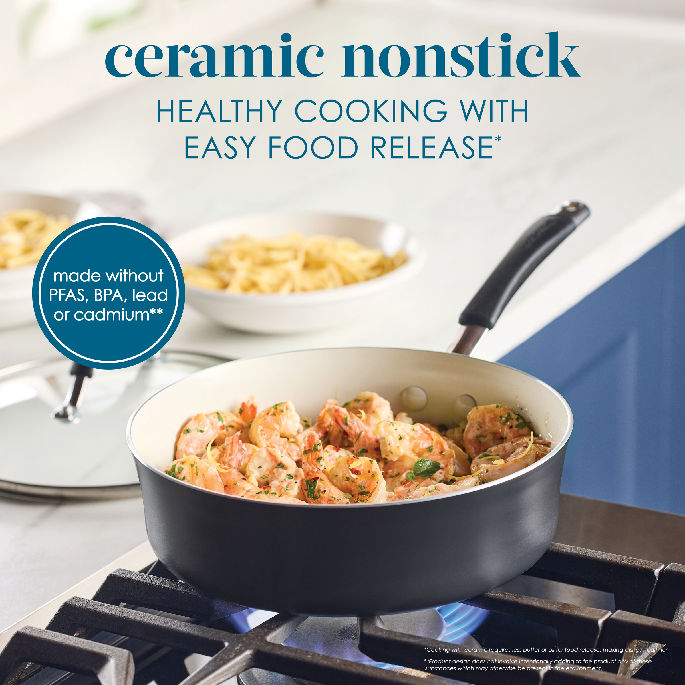 Cooking shrimp in a nonstick pan on a stovetop with pasta in the background.