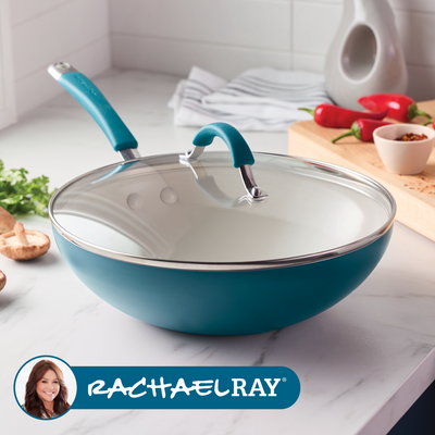 Blue nonstick wok with a glass lid on a kitchen countertop.