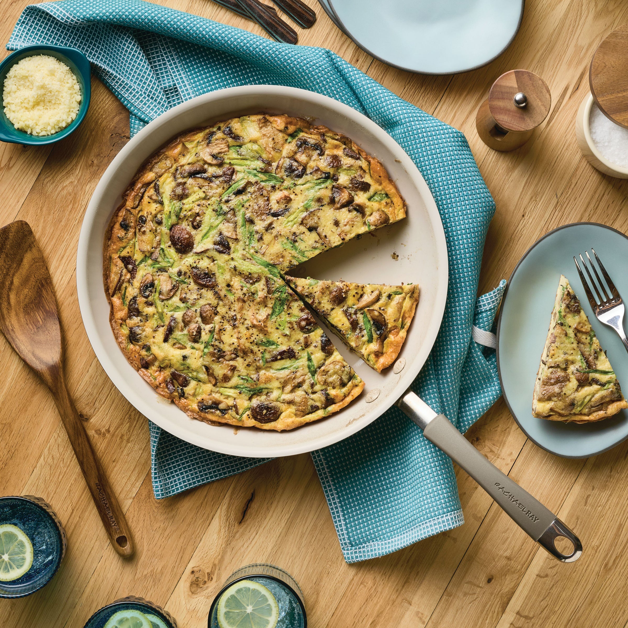 Frittata in a skillet with one slice served on a plate, on a wooden table.