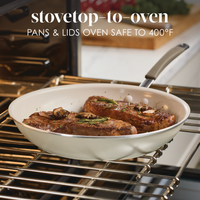 Steak cooking in an oven-safe skillet on a rack in the oven.
