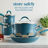 Blue cookware set with lids and pan protectors, placed on a kitchen counter.