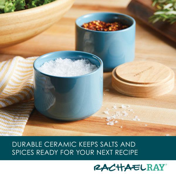 A Stacking Spice Box Set featuring two blue ceramic containers with salt and spices rests elegantly on a wooden surface.