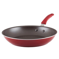 Introducing the Cook + Create Nonstick Frying Pan: a high-performance red pan with a black interior and an ergonomic red handle, crafted from thicker gauge aluminum for durability and even heat distribution.