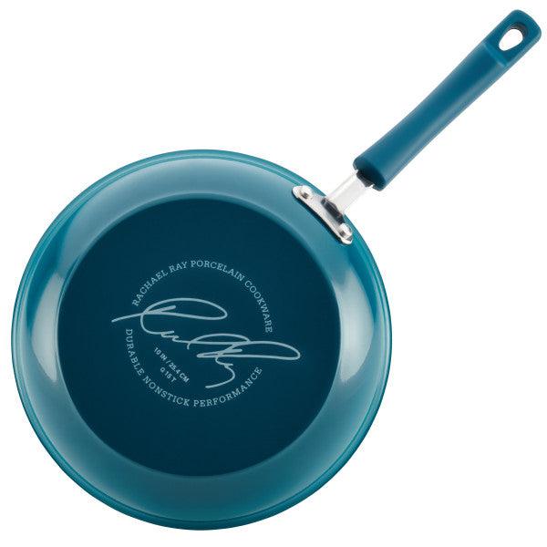 The Classic Brights Nonstick Cookware Set includes a versatile blue frying pan with a signature and descriptive text on the bottom, guaranteeing both quality and style.