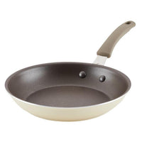 The Cook + Create Nonstick Frying Pan is a high-performance kitchen tool crafted from thicker gauge aluminum, featuring a sleek side view with its light-colored handle and base.