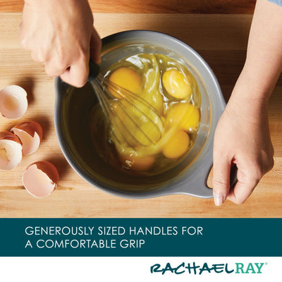 Hands whisking eggs in a bowl with eggshells on the side.