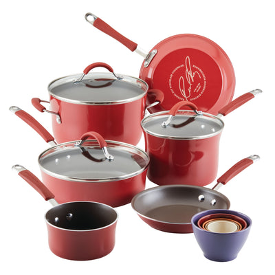 Red cookware set with lids and nested measuring bowls.