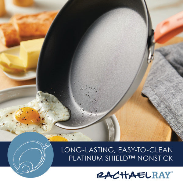 A frying pan, part of the 10-Piece Classic Brights Hard Anodized Nonstick Cookware Set, tilts to elegantly serve eggs onto a plate, while butter and bread stand ready in the background. This reliable cookware ensures every breakfast is effortlessly delightful.