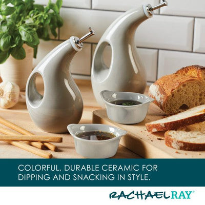 Ceramic bottles and dipping bowls with bread on a kitchen counter.