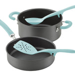 Two nonstick pans with teal handles and matching kitchen utensils.