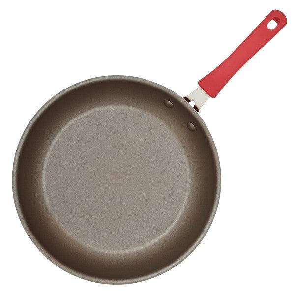 The Cook + Create Nonstick Frying Pan, featuring a red handle and constructed from thicker gauge aluminum, is showcased on a white background.