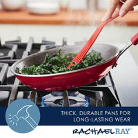 A high-performance Cook + Create Nonstick Frying Pan, with its striking red design, rests on the stove as vibrant greens are being stirred by a red spatula. Made from thicker gauge aluminum, this pan promises a seamless cooking experience every time.