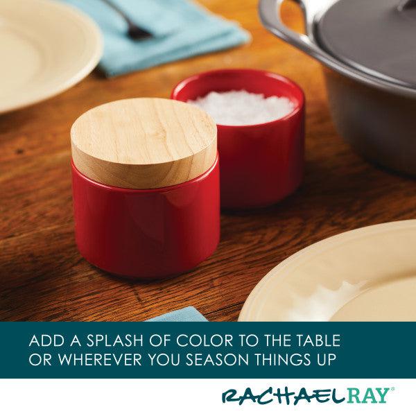A ceramic red salt cellar with a wooden lid from the Stacking Spice Box Set complements the table setting, effortlessly fitting in alongside other spice boxes.