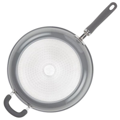 Top view of a nonstick frying pan with a black handle on a white background.