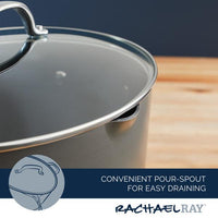 The 8-Quart Professional Nonstick Oval Hard Anodized Stockpot, complete with a glass lid and pour spout for easy draining, is elegantly resting on a wooden surface.