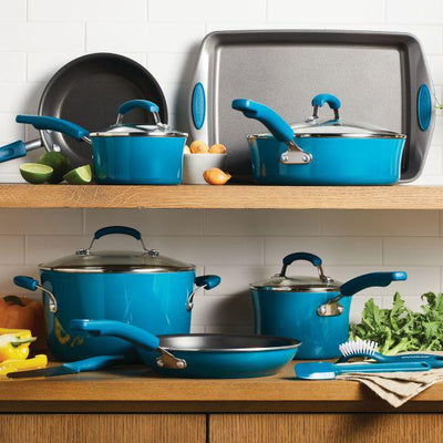 A set of blue cookware and vegetables on wooden kitchen shelves.