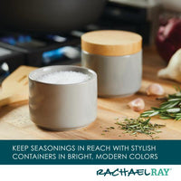 The Stacking Spice Box Set, with one box open to show salt, is surrounded by rosemary and garlic.