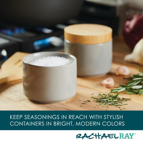 The Stacking Spice Box Set, with one box open to show salt, is surrounded by rosemary and garlic.