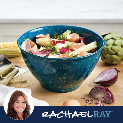 Blue bowl with mixed vegetable scraps and eggshells on a kitchen counter.