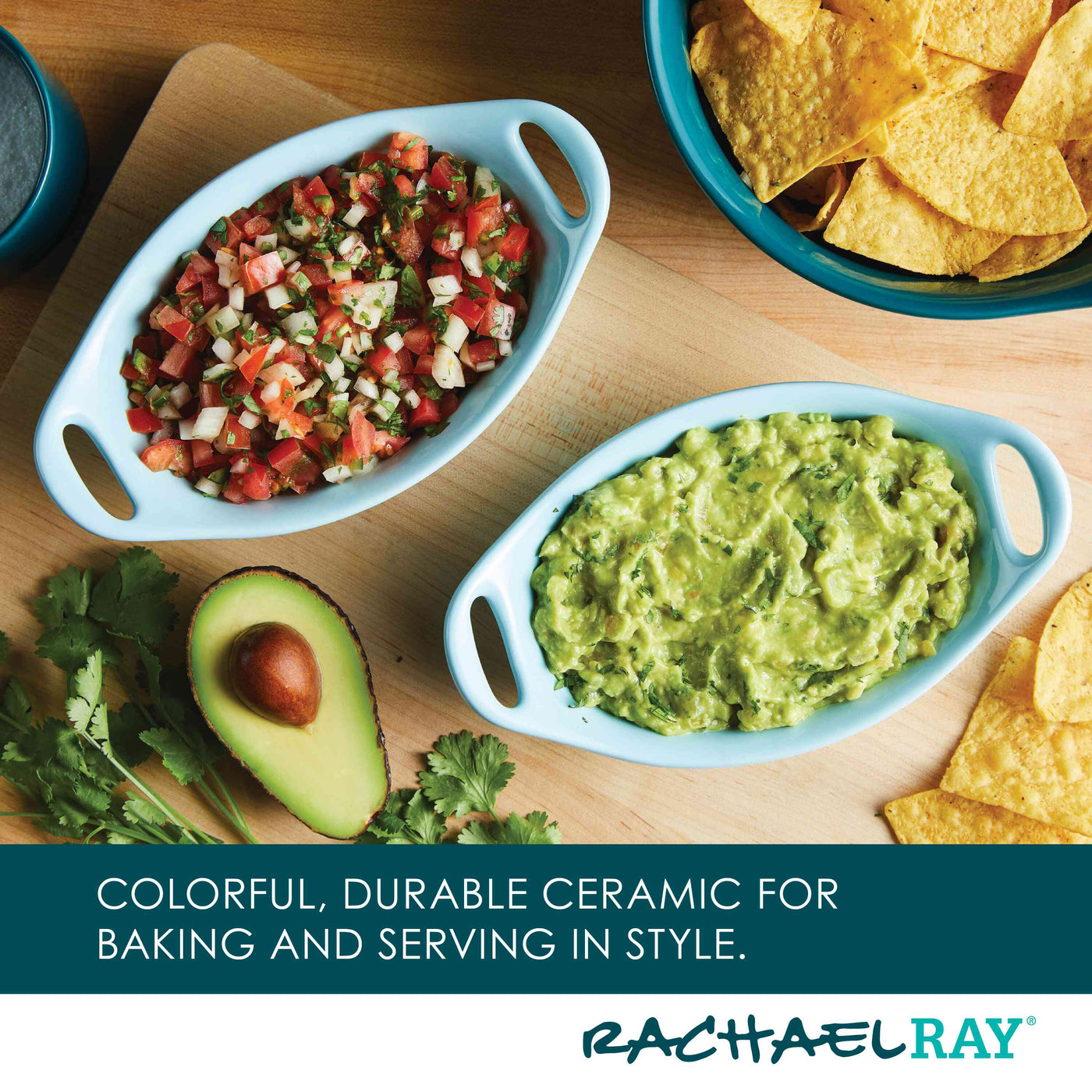 Ceramic dishes with salsa and guacamole, chips, and an avocado on a board.