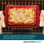 Hands holding a red baking dish with lasagna in an oven.