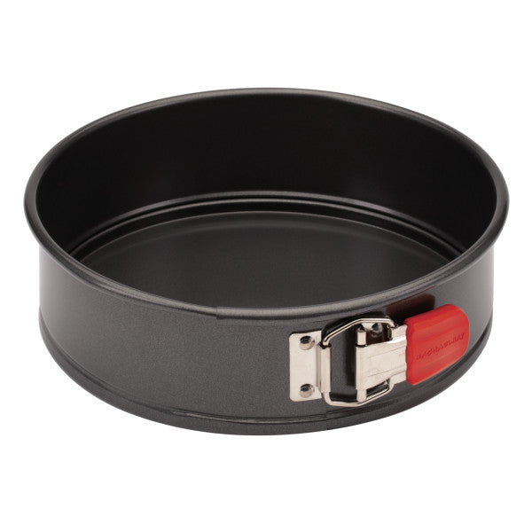 The 9-Inch Nonstick Springform Pan is designed with a black round shape, crafted from heavy gauge steel, and includes a red latch on the side to facilitate easy food release.