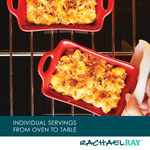 Two red dishes of baked mac and cheese in an oven; hand holding one dish.
