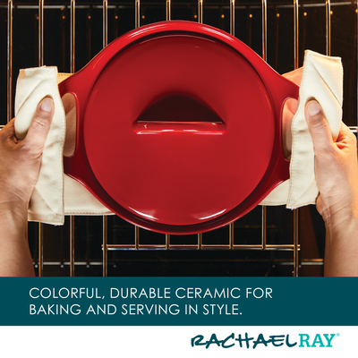 Person holding a red ceramic dish on an oven rack.