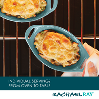 Hand holding dish of baked cheesy casserole on oven rack.