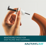 Close-up of a hand holding a removable spout above a brown container.