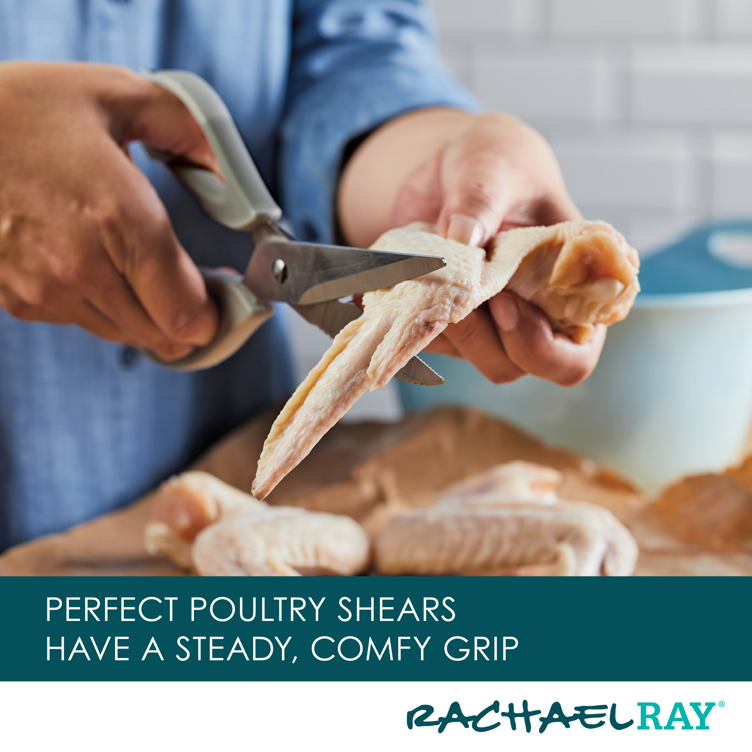 Person using poultry shears to cut raw chicken wings in a kitchen.